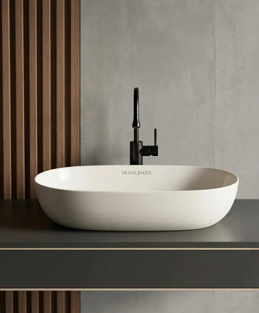 White oval vessel sink with matte black faucet on dark countertop