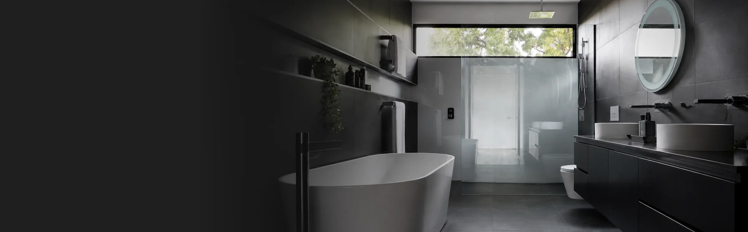 Contemporary bathroom with freestanding tub and backlit mirror