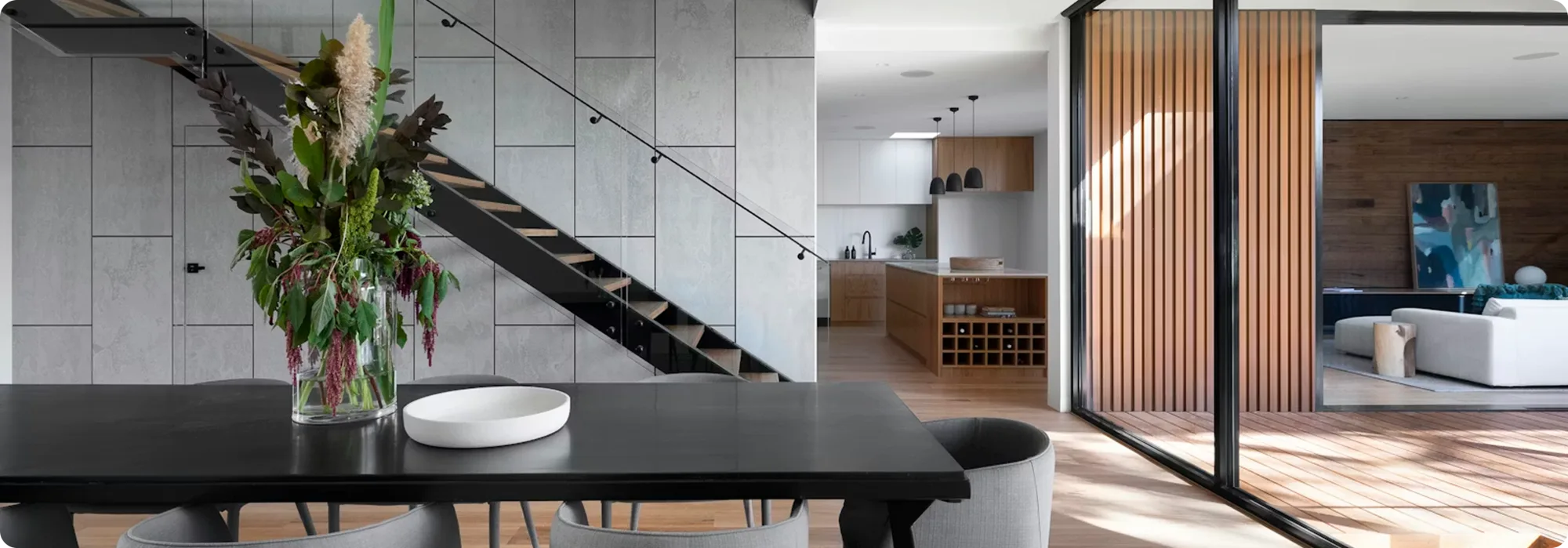 Open-plan interior with dining table, kitchen and natural light