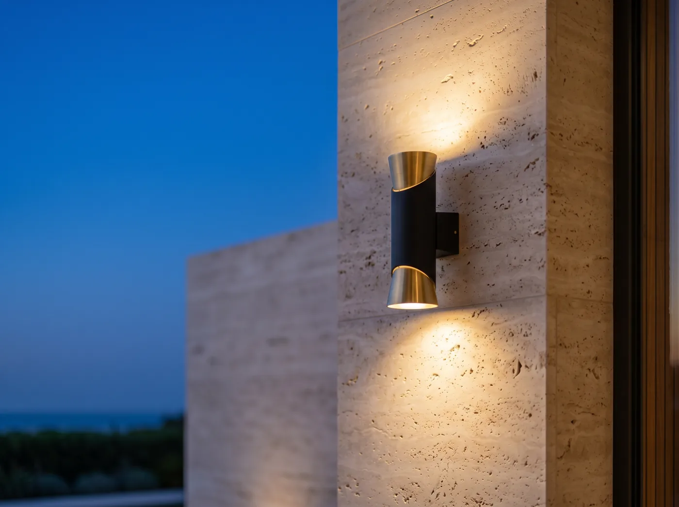 Outdoor up-and-down wall light in brass and dark metal on travertine