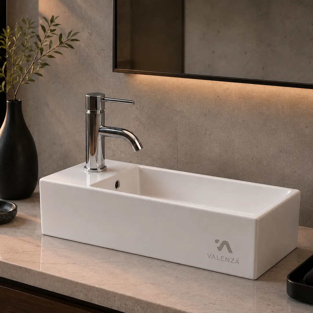 Slim elongated white basin for compact bathrooms with a side-mounted chrome mixer
