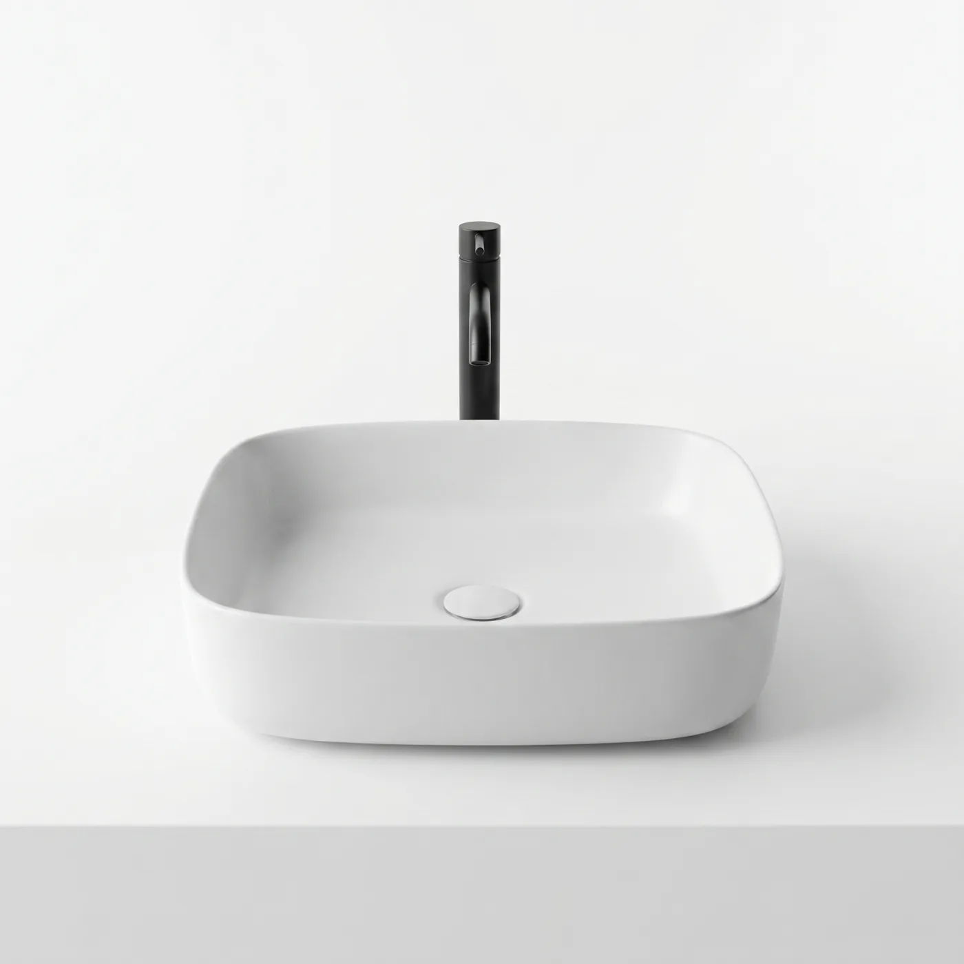 Soft-cornered square ceramic vessel basin in matte white with a black mixer