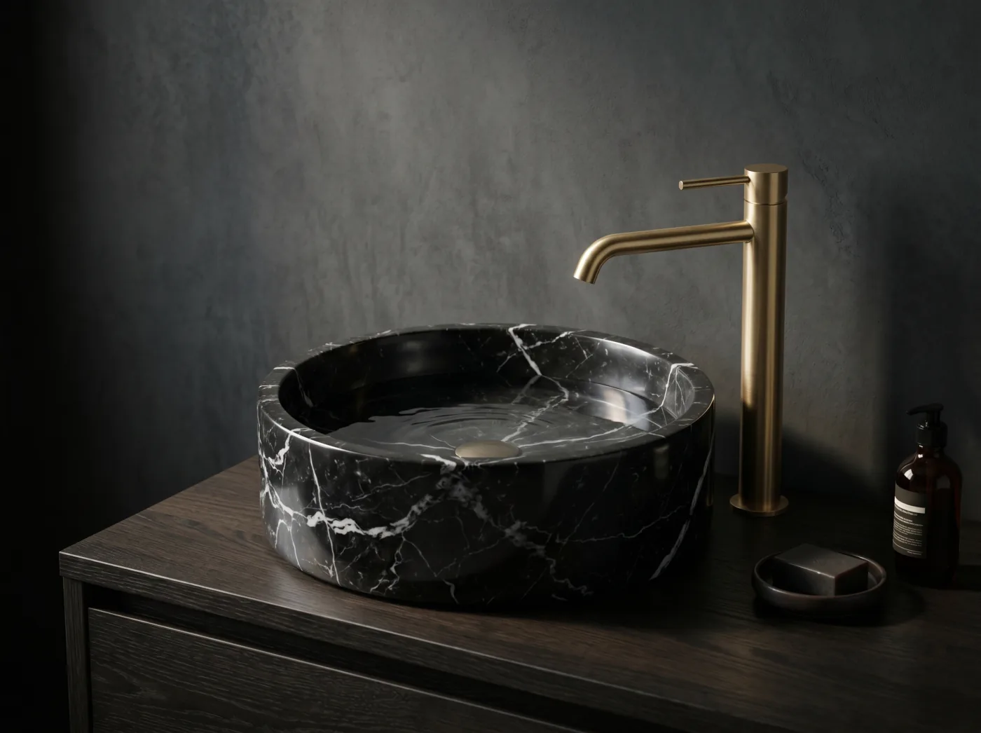 Round vessel basin in veined black marble with a brass mixer