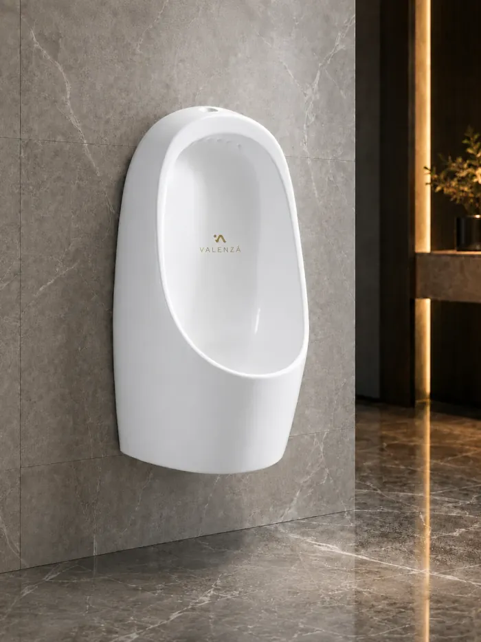 Rounded wall-hung urinal in white ceramic against grey marble